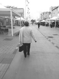 Woman standing on footpath