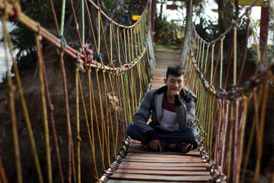 Young man standing on footbridge