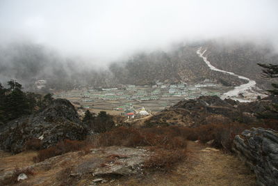 Scenic view of landscape against sky during foggy weather