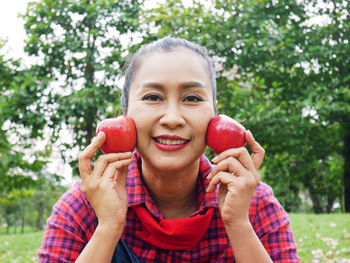 Portrait of smiling woman holding apple
