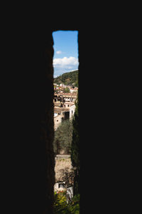 Buildings against sky seen through window