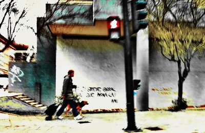 Rear view of men walking on street amidst buildings