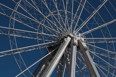 Low angle view of ferris wheel against blue sky