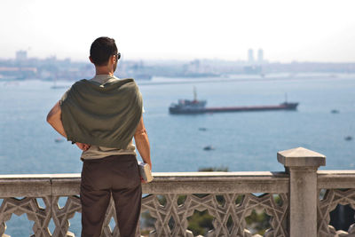 Rear view of man standing on pier