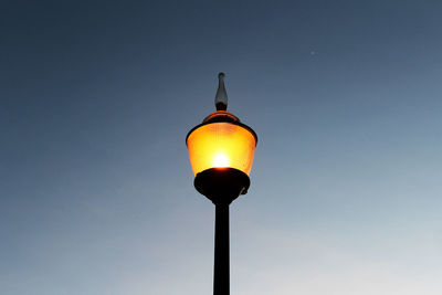 Low angle view of illuminated street light against clear sky at night.