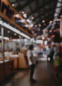 Defocused image of people walking on illuminated glass window