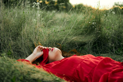 Midsection of woman relaxing on field