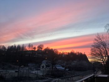 Snow covered trees against sky during sunset