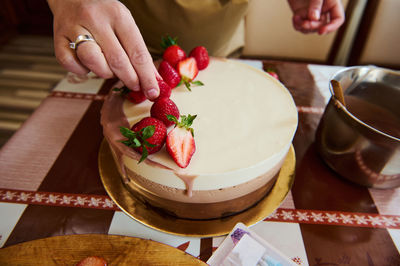 Cropped hand of woman preparing food on table