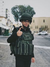 Portrait of boy wearing military costume while standing on street