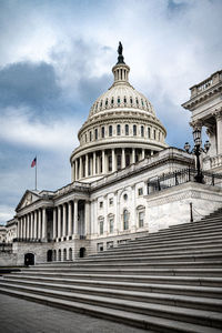 Facade of the united states capitol building in washington, d.c. on a cloudy and moody day. 