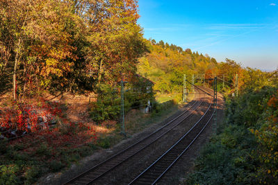 Railroad tracks by trees against sky during autumn