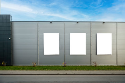 Three blank white billboard for advertisement on the facade of building, outdoor advertising mockup