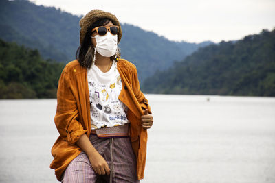 Portrait of woman standing against lake