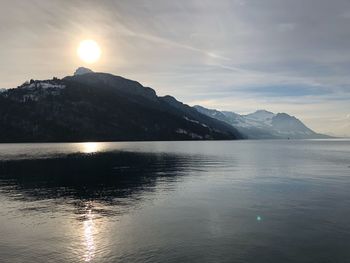 Scenic view of sea and mountains against sky