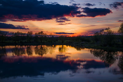 Scenic view of lake against sky at sunset
