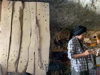 Side view of man standing against wall
