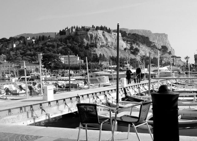 nautical vessel, water, moored, sea, boat, transportation, mode of transport, sky, chair, beach, clear sky, mountain, relaxation, shore, men, day, table, harbor, sitting