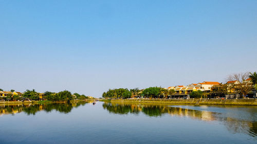 Scenic view of lake by building against clear sky