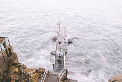 High angle view of woman on pier over sea