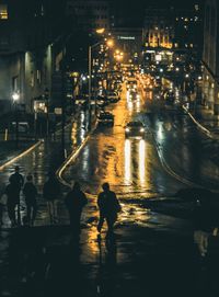 People on wet street during rainy season at night