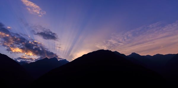 Scenic view of silhouette mountains against sky at sunset