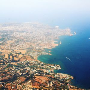 Aerial view of sea and cityscape against sky