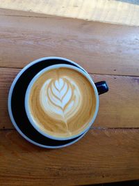 Directly above shot of coffee cup on wooden table