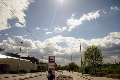 Cars on road against cloudy sky