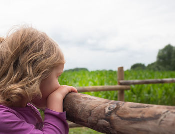 Close-up of girl hand against sky