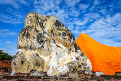 Rock formation against cloudy sky