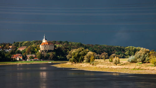 View of river amidst buildings against sky