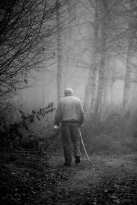 Rear view of senior man walking at forest