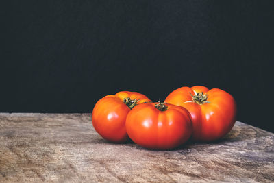 Close-up of tomatoes on table against black background