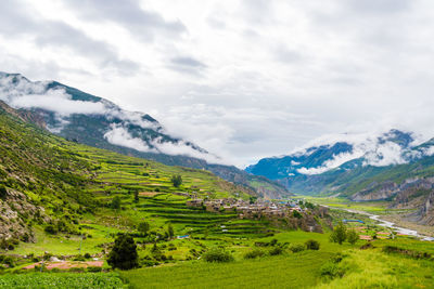 Scenic view of field and mountains against sky