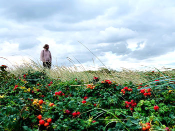 Man looking away while standing on field against sky