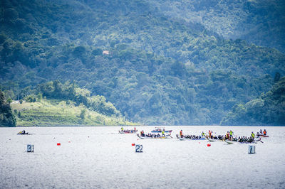 Dragon boat race in river against mountain