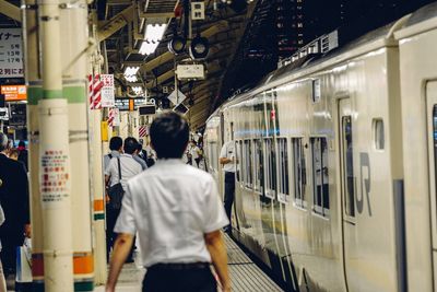 Rear view of people on train at railroad station