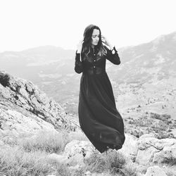 Woman standing on landscape against mountain