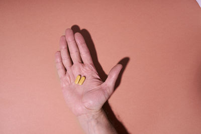 Close-up of human hand against wall