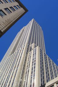 Low angle view of modern buildings against clear blue sky