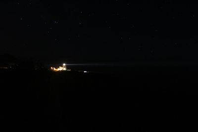 Illuminated landscape against sky at night