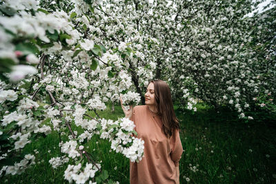 Beautiful young girl in the garden of blooming apple trees