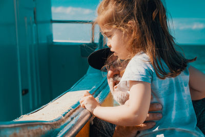 Grandfather and granddaughter by boat at beach