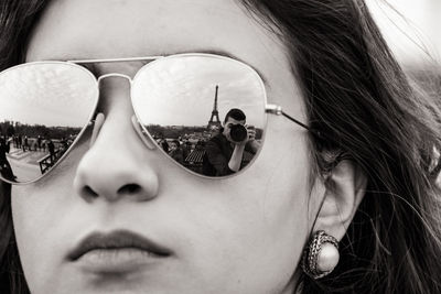 Close-up of woman with reflection of eiffel tower in sunglasses