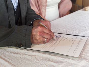 Senior couple marrying, groom signing document in register office