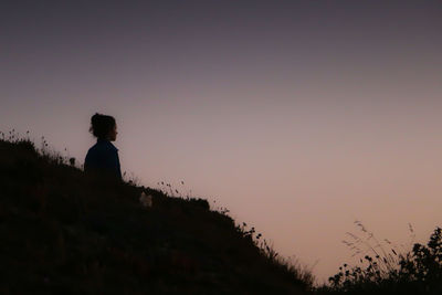 Silhouette woman looking at sunset