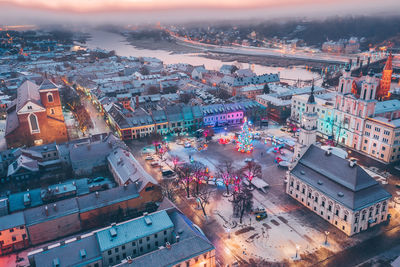 Aerial view of illuminated cityscape against sky during sunset