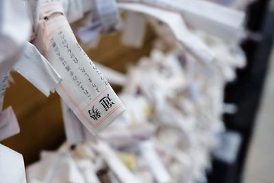 Close-up of papers tied on fence