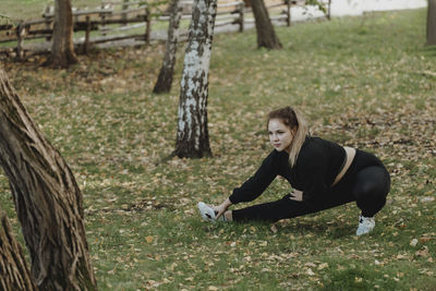 Plus sized woman doing stretching exercise in park